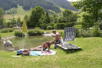 Paar auf Handtüchern und Liegestühlen direkt am See