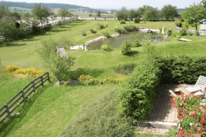 Bild von oben über die Terrasse , die Wiesen, den Hang hinab