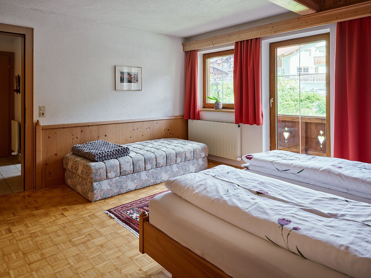 Blick über das Bett aus dem Schlafzimmer heraus